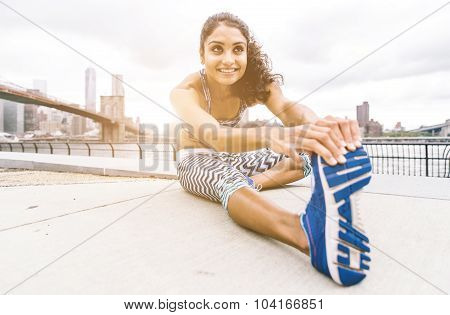 Young Woman Making Stretching In New York City. Brooklyn Bridge And Skyline In The Background