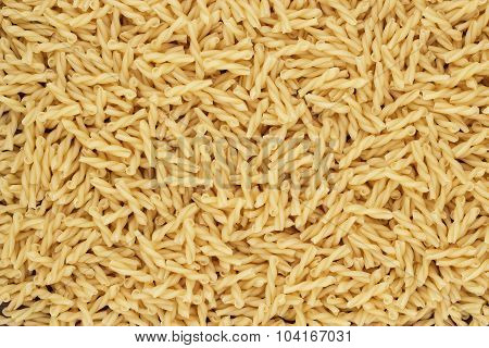 dry uncooked gemelli pasta texture background