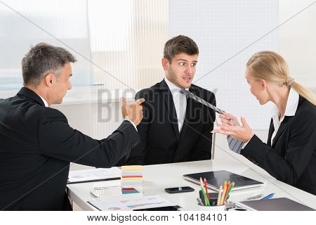 Two Businesspeople Quarreling To Young Businessman