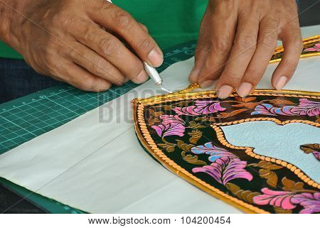 Malaysian kite maker working on a kite in his workshop