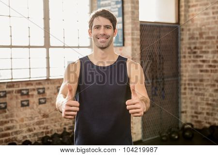 Portrait of a man showing thumbs up at the gym