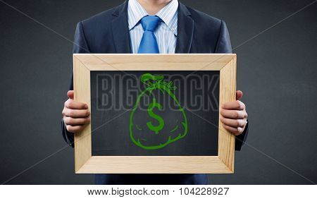 Unrecognizable businessman holding blackboard with drawn dollar concept