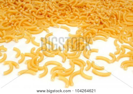 closeup of a pile of uncooked macaroni on a white background