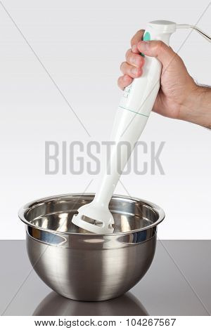 Holding a hand mixer in a bowl