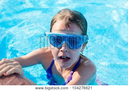Happy Girl In Blue Goggles Swimming In The Swimming Pool