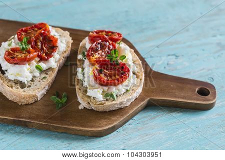 Sandwich With Goat Cheese, Sun-dried Tomatoes And Thyme, Served On The Board At A Bright Wooden Surf