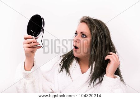 Brown Haired Woman Looking Shocked At Herself In A Mirror