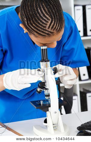 cientista olhando através do microscópio
