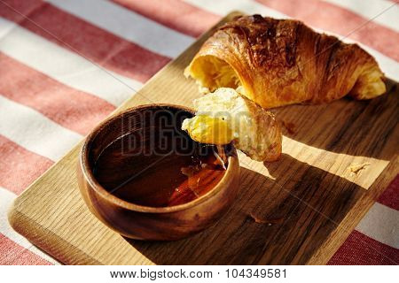 Freshly Baked French Croissant Dip In Honey Wooden Pot On Stripe Cloth