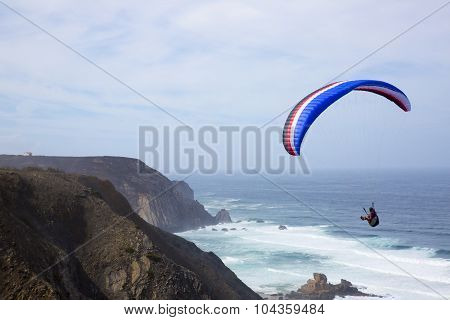 Paragliding Above The Ocean At Castelejo Beach In Portugal