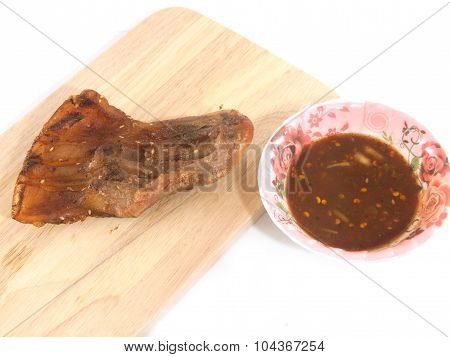 Pork neck grilled with spicy sauce on cutting board