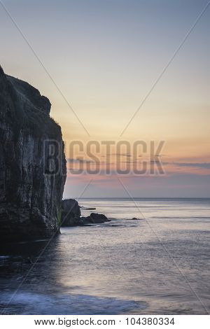 Stunning Coastal Landscape With Long Exposure Waves Crashing At Sunrise