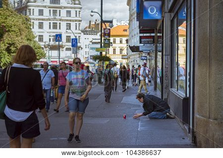 A homeless beggar is begging on a busy street