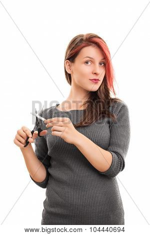 Stop this bad habit! Beautiful young girl cutting a cigarette with scissors, isolated on white background.