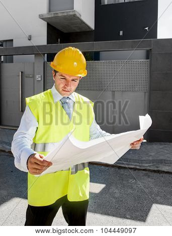 Young Attractive Foreman Worker Supervising Building Blueprints Outdoors Wearing Construction Helmet
