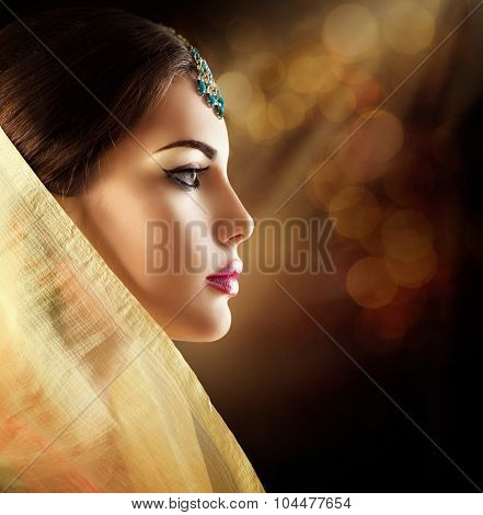 Beautiful fashion Indian woman profile portrait with oriental accessories. Indian girl with beauty jewels. Hindu model with perfect make-up. India