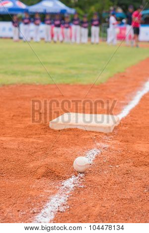 Baseball And Base On Baseball Field With Players And Coach On Background