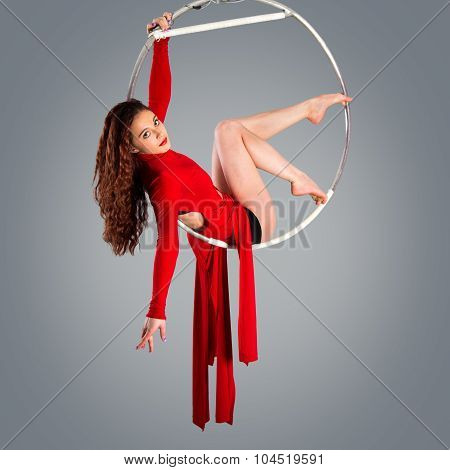 Plastic Beautiful Girl Gymnast On Acrobatic Circus Ring In Flesh-colored Suit. Aerial Ring.