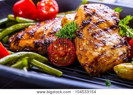 Grilled chicken breast in different variations with cherry tomatoes, green French beans, garlic