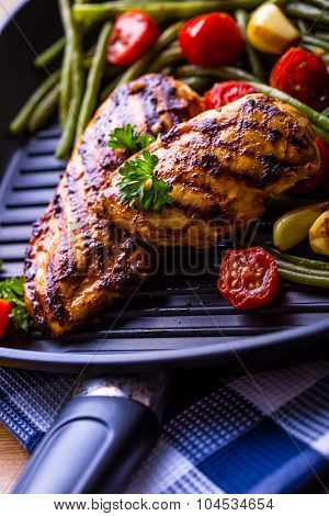 Grilled chicken breast in different variations with cherry tomatoes, green French beans, garlic