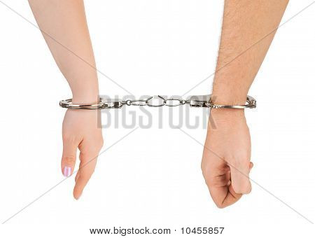 Mani di uomo e donna e manette di rottura