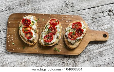 Sandwich With Goat Cheese, Sun-dried Tomatoes And Thyme, Served On The Board At A Bright Wooden Surf