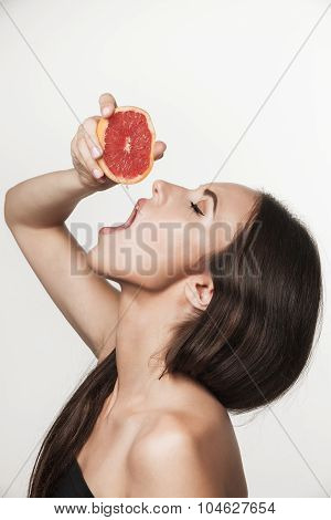 Portrait Of Young Woman Eating Grapefruit