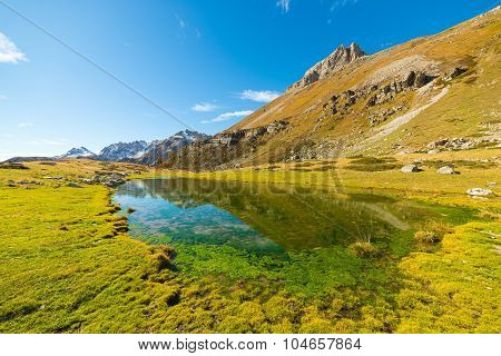 High Altitude Green Alpine Lake In Autumn Season