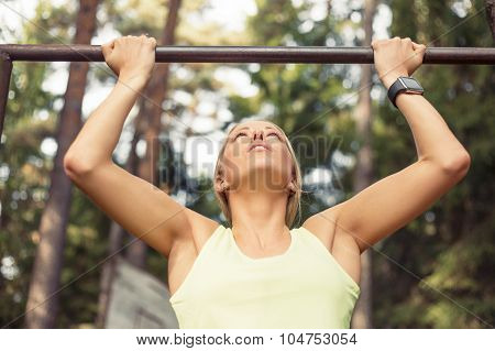 Athletic woman doing pull up
