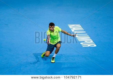 KUALA LUMPUR, MALAYSIA - OCTOBER 02, 2015: Grigor Dimitrov of Bulgaria hits a backhand return in his match at the Malaysian Open 2015 tennis tournament held at the Putra Stadium, Malaysia.