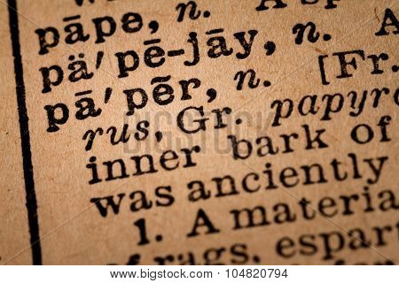 Close-up Of An Opened Dictionary Showing The Word Paper