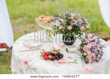 Served table outdoors. Flower arrangement with lavender and roses. Wedding decorations.
