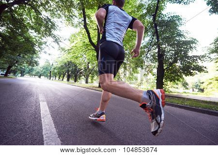 healthy athlete man jogging at morning on empty  roat in the city