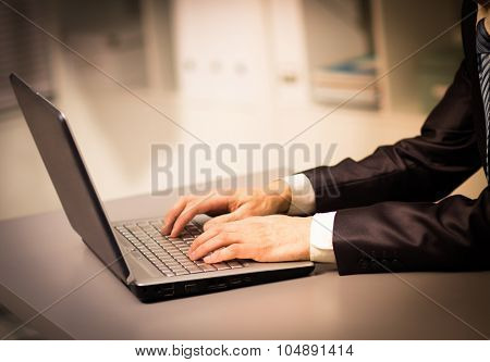 Person Typing on a modern laptop in an office