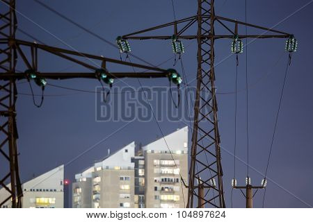 High power electricity poles in urban area at night