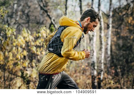 young male athlete running in autumn Park