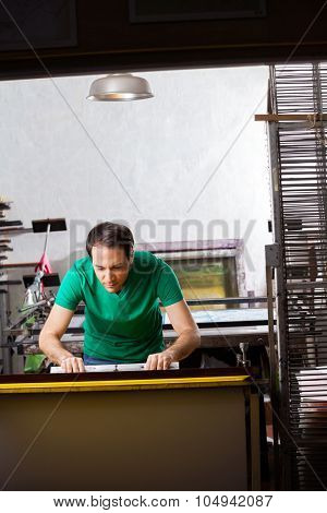 Mid adult worker using squeegee in paper factory
