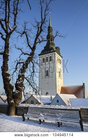 winter view of St. Nicholas' Church's spire seen from a park in Tallinn, Estonia