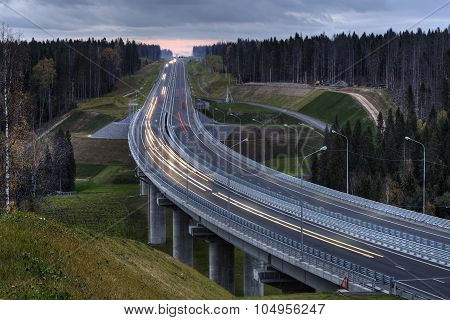 A Highway Crosses The Russian Forest At Night.