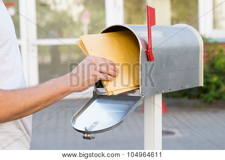 Person Removing Letters From Mailbox