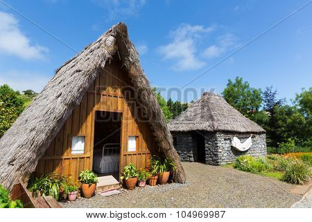 Forecourt of hut with green grass and trees