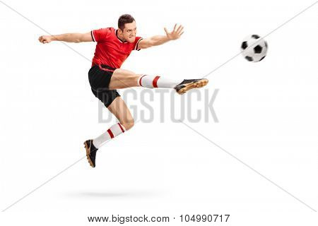 Studio shot of a male football professional kicking a ball in mid-air isolated on white background