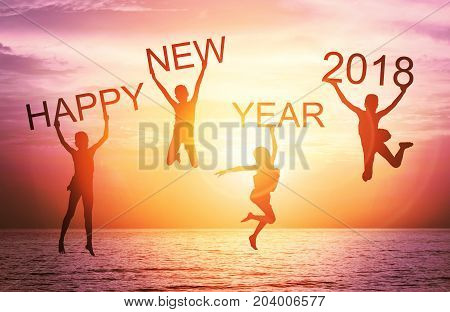 Happy new year card 2018. Silhouette of children girl jump on tropical beach with fantastic sunset sky background. Kids holding the word happy new year and number 2018 with sea and sunrise background.