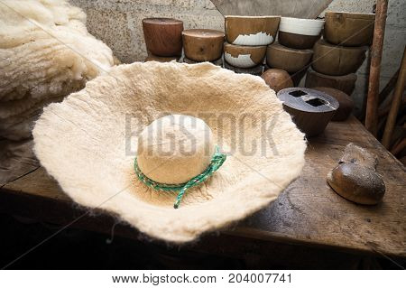 April 21 2017 Iluman Ecuador: felt hat on workbench in artisan shop tied on a wood form