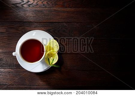 Green tea with lemon and mint on wooden table background with copy space