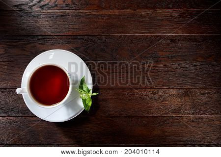 Green tea with lemon and mint on wooden table background with copy space