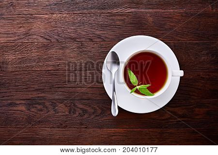 Green tea with lemon and mint on wooden table background with copy space