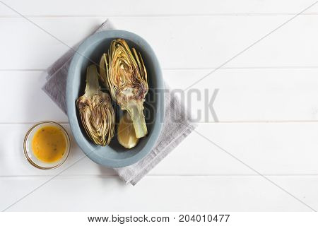 Artichokes and lemons on the plate. This product has one of the highest antioxidant capacities. Traditional vegetables in italian cuisine