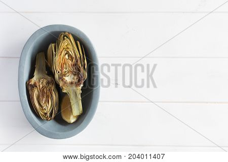 Artichokes and lemons on the plate. This product has one of the highest antioxidant capacities. Traditional vegetables in italian cuisine