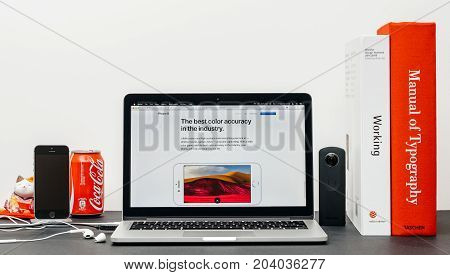 PARIS FRANCE - SEP 13 2017: Minimalist creative room table with Safari Browser open on MacBook Pro laptop showcasing Apple Computers website with latest iPhone 8 and 8 Plus with best color accuracy